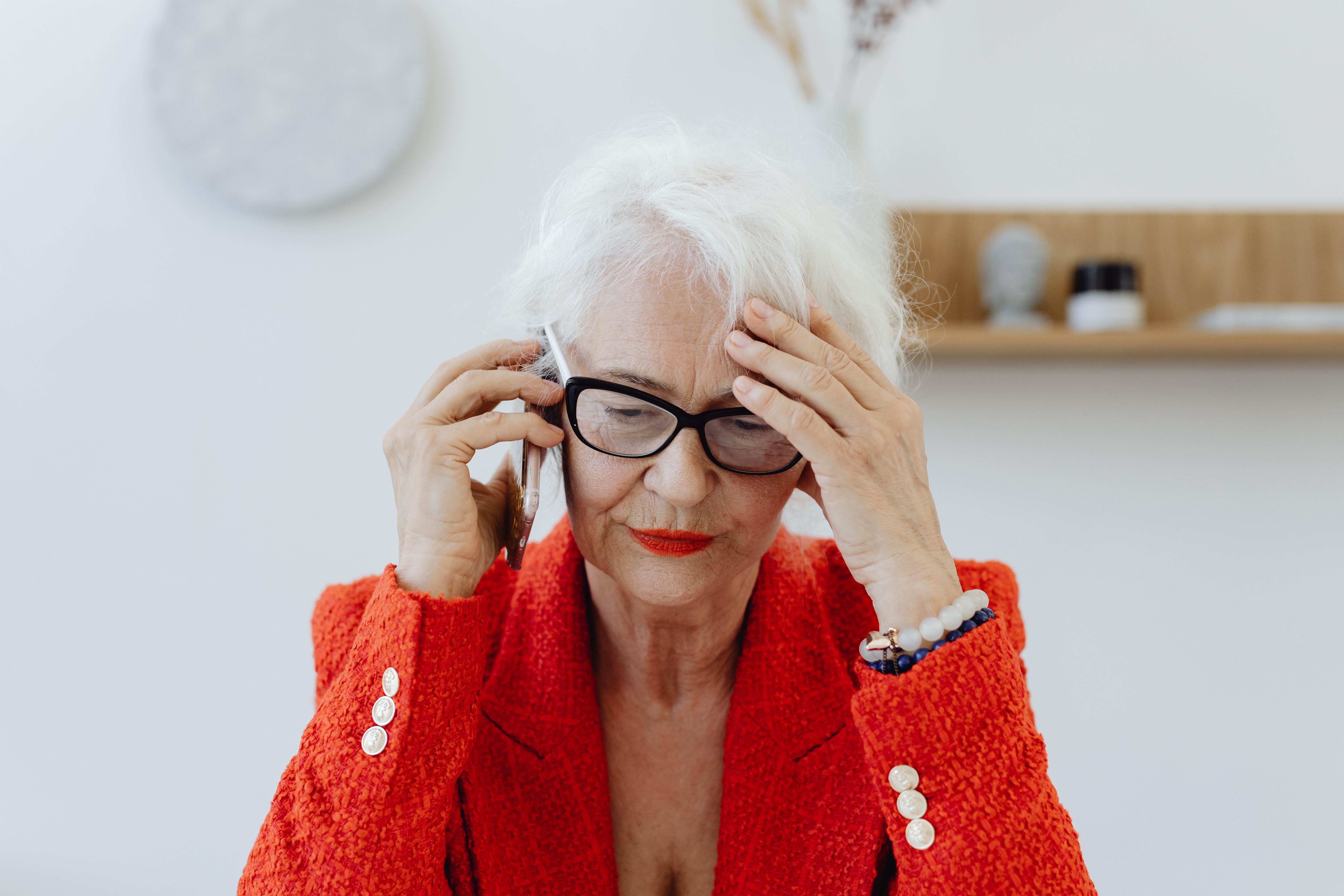 Older woman looking stressed while talking on the phone. 
